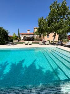 a swimming pool in front of a house at 4 bedrooms villa with private pool furnished garden and wifi at Uceda in Uceda