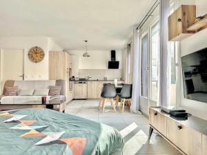 Cet appartement comprend une chambre avec un lit et une cuisine avec un canapé. dans l'établissement ZenBNB - Le Citadin - STUDIO - 2 minutes from the Train station, à Annemasse