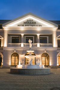 a large building with a fountain in front of it at Muller Hotel Boutique & Spa in Galaţi