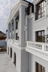 uma casa branca com varandas e uma varanda em Muller Hotel Boutique & Spa em Galaţi