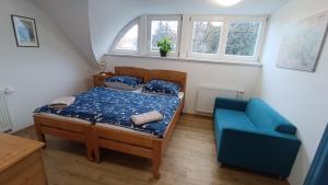 sypialnia z łóżkiem i niebieską kanapą w obiekcie Apartmány stará škola w Swobodzie nad Upą