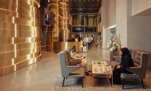 two women sitting in chairs in a lobby at Aerotel Muscat - Airport Transit Hotel in Muscat