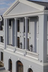 a white house with columns and a balcony at Muller Hotel Boutique & Spa in Galaţi