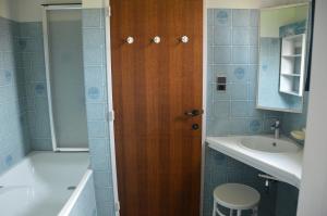 a bathroom with a wooden door and a sink at Lovely Holiday Home in Merksplas with Fenced Garden in Merksplas