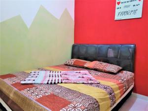 ein Bett mit Kissen darauf in einem Zimmer in der Unterkunft MG Villa in Tlekung