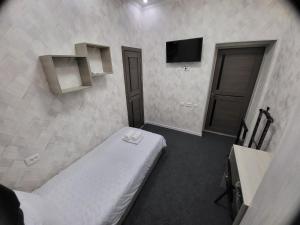 Cette petite chambre comprend un lit et une télévision. dans l'établissement Shahriston GH, à Tachkent