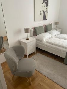 a living room with a bed and a chair at Apartment Congress Graz in Graz