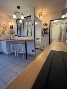 a kitchen with a table and a mirror at L’Atelier de la dépendance in Lempdes sur Allagnon