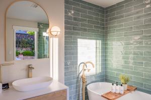 y baño con bañera, lavabo y espejo. en @ Marbella Lane - Vibrant & Chic Designer Home, en Fullerton