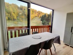 stół i krzesła w pokoju z dużym oknem w obiekcie Studio Rénové 4 Pers. au Pied des Pistes avec Parking Gratuit - Résidence Les Fontettes, La Joue du Loup - FR-1-504-646 w mieście Dévoluy