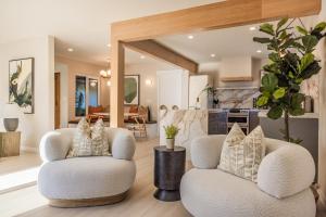 a living room with two chairs and a kitchen at @ Marbella Lane - Vibrant & Chic Designer Home in Fullerton