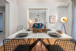 a dining room with a white table and chairs at Luxury 2 bdroom apt- Megaro Mousikis in Athens