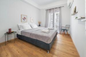 a white bedroom with a large bed and a window at Luxury 2 bdroom apt- Megaro Mousikis in Athens