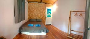 a bedroom with a bed with blue slippers on it at Bamboo Hut Bangalow in Ko Mook