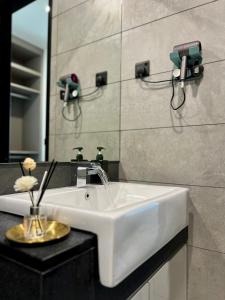 bagno con lavandino bianco e specchio di EUcation Home - Opus Residence a Kuala Lumpur