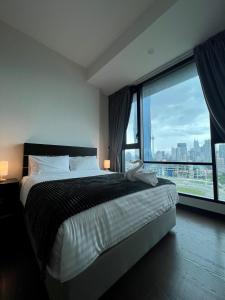 a bedroom with a bed and a large window at EUcation Home - Opus Residence in Kuala Lumpur