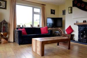 a living room with a couch and a fireplace at Beautiful House on Wild Atlantic Way - 6 bedrooms in Kenmare