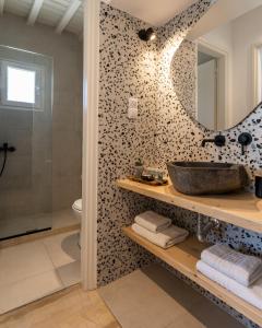 a bathroom with a sink and a mirror at Haka Suites Mykonos Town in Mikonos