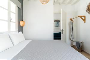 um quarto com uma cama branca e uma janela em Haka Suites Mykonos Town em Míconos