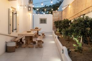 un patio extérieur avec des bancs, des tables et des lumières dans l'établissement Haka Suites Mykonos Town, à Mykonos