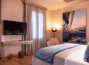 a hotel room with a bed and a flat screen tv at Miramare Suites in Sestri Levante