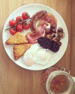 a plate of breakfast food with eggs bacon and tomatoes at Dawn Chorus Holidays in Beccles
