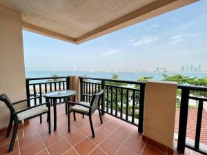 a balcony with a table and chairs and the ocean at Luxury residential apartments located in Anantara area , pool , beach , free parking in Dubai