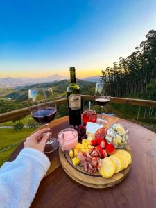 a table with a plate of food and two glasses of wine at Recanto Ágape in Santo Amaro da Imperatriz +14 photos