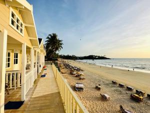 a beach with a building and people on the beach at Cocos Beach Resort in Palolem