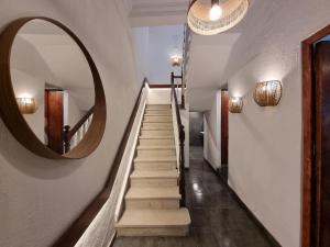 a hallway with a round mirror and stairs at Compass House in Las Palmas de Gran Canaria