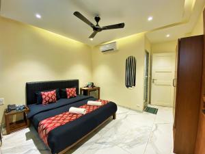a bedroom with a bed and a ceiling fan at Wotel Calangute Goa in Calangute