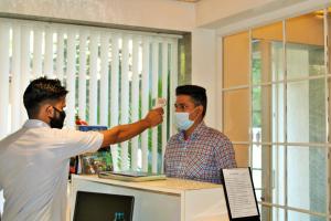 a man in a face mask holding a video game controller at Wotel Calangute Goa in Calangute