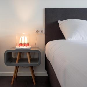 ein Bett und einen Tisch mit einer Lampe neben einem Bett in der Unterkunft Hello Zeeland - Vakantiehuis Beatrixstraat 29A in Domburg