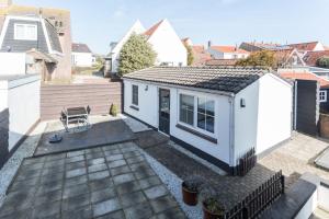 a small white tiny house on a roof at Hello Zeeland - Vakantiehuis Beatrixstraat 29A in Domburg