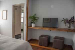 a bedroom with a bed and a television on a shelf at Casa Reconquista in Mendoza