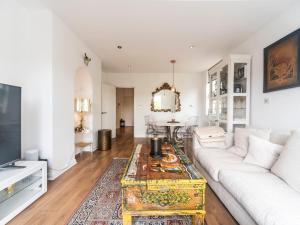 ein Wohnzimmer mit einem weißen Sofa und einem Tisch in der Unterkunft Pass the Keys Luxurious Flat with Large Private Terrace in Hanworth