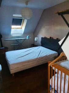 Schlafzimmer mit einem Bett und einer Decke mit einem Fenster in der Unterkunft Maison de 3 chambres avec jardin clos a Val d'Oust in La Chapelle-Caro
