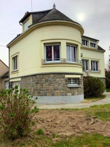 ein großes gelbes Haus mit einem runden Turm in der Unterkunft Maison de 3 chambres avec jardin clos a Val d'Oust in La Chapelle-Caro