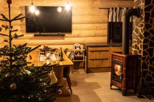 a living room with a wood stove and a christmas tree at Zrúboček / Log Cabin in Liptovský Trnovec