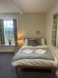 ein Schlafzimmer mit einem Bett mit zwei Handtüchern darauf in der Unterkunft Home Farm rooms in the grounds of Wentworth Castle in Barnsley