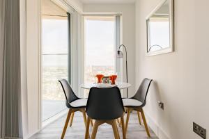 a dining room with a table and chairs and a window at CitySpace Acton in London