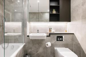 a bathroom with a sink and a toilet and a tub at CitySpace Acton in London
