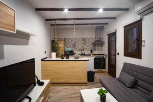 a kitchen and a living room with a couch and a kitchen at Casa Antequeruela in Toledo