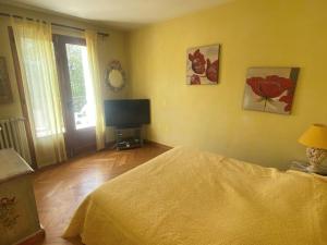 ein Schlafzimmer mit einem Bett und einem Flachbildfernseher in der Unterkunft Belle maison au centre de Villard de Lans avec grande terrasse et jardin - FR-1-515-4 in Villard-de-Lans