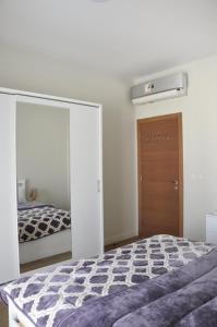 Schlafzimmer mit einem Bett und einem Spiegel in der Unterkunft Axxodia Mivida Boulevard New cairo in New cairo