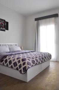 ein Schlafzimmer mit einem Bett und einem großen Fenster in der Unterkunft Axxodia Mivida Boulevard New cairo in New cairo