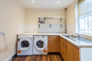 eine Waschküche mit einer Waschmaschine und einem Waschbecken in der Unterkunft Oak Room in Liverpool