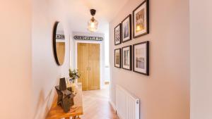 a hallway with white walls and pictures on the wall at Nala's Nest in Hexham