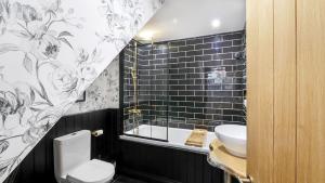 a black and white bathroom with a toilet and a sink at Nala's Nest in Hexham
