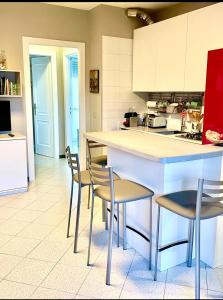 uma cozinha com um balcão e cadeiras em Casa Ginestra Mare em Bordighera